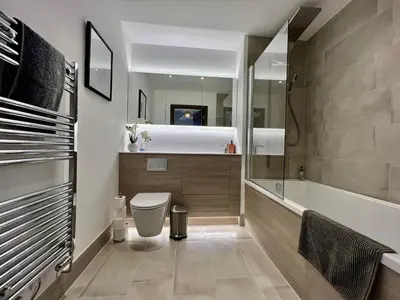 a bathroom with a toilet and a bath tub at Walnut Tree Penthouse Next to Train Station in Cambridge
