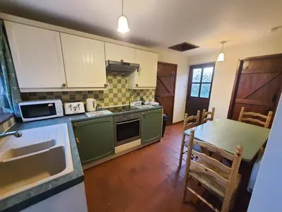 a kitchen with green appliances and a table with chairs at Cosy Barn Conversion 3BR (4 pax), Quiet, Close to Pin Mill in Chelmondiston