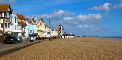 a row of houses on the beach with cars parked at SkyFall in Grundisburgh