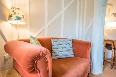 a brown leather couch in a living room with a lamp at Ivy House, Mells in Halesworth