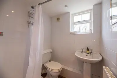 a white bathroom with a toilet and a sink at Ivy House, Mells in Halesworth