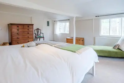 a white bedroom with a large bed and a dresser at Ivy House, Mells in Halesworth