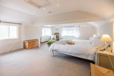 a white bedroom with a large bed and two windows at Ivy House, Mells in Halesworth