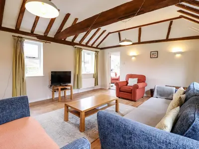 a living room with couches and a tv at The Brambles in Colchester