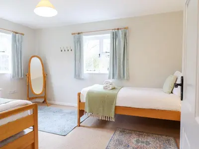 a small bedroom with two beds and a mirror at The Brambles in Colchester