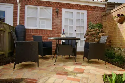 a patio with chairs and a table in a backyard at Cottage in Framlingham in Framlingham