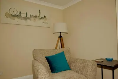 a chair with a blue pillow in a room at Cottage in Framlingham in Framlingham