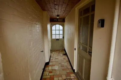 an empty hallway with a door and a window at Cottage in Framlingham in Framlingham