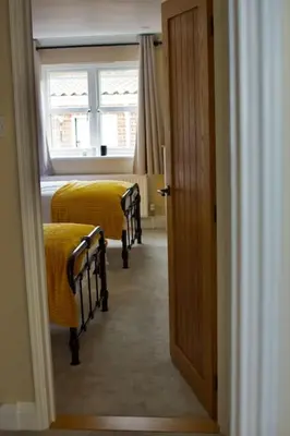 a room with two beds and a window at Cottage in Framlingham in Framlingham