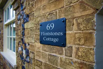 a blue sign on the side of a brick building at Cottage in Framlingham in Framlingham