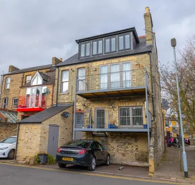 a brick house with a car parked in front of it at R&O Property Experts - Diamond 2BR Apartment-Central-Parking-Walk to city & train station in Cambridge