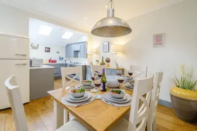 a kitchen and dining room with a table and chairs at Shearwater Cottage in Aldeburgh