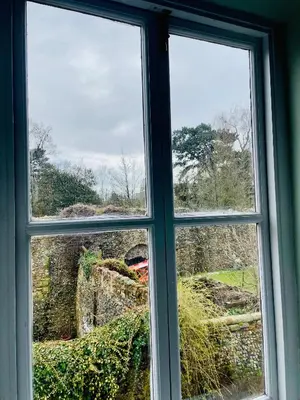 a window with a view of a field seen through it at Abbey Gardens Cottage in Bury Saint Edmunds
