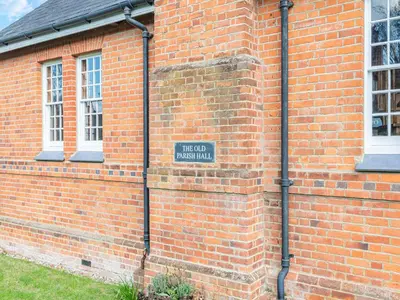a brick building with a sign on the side of it at The Old Parish Hall in Quendon