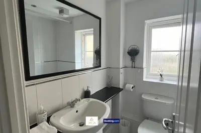 a bathroom with a sink and a toilet and a mirror at 3 Bedroom House By Trinity Stays Short Lets & Serviced Accommodation Cambridge With Free WiFi & Parking in Cambridge