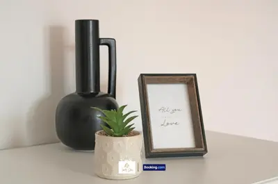a plant sitting next to a black vase and a picture at 3 Bedroom House By Trinity Stays Short Lets & Serviced Accommodation Cambridge With Free WiFi & Parking in Cambridge