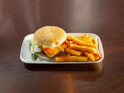 a plate with a hamburger and french fries on a table at Stay Inn Express, Cambridge in Cambridge