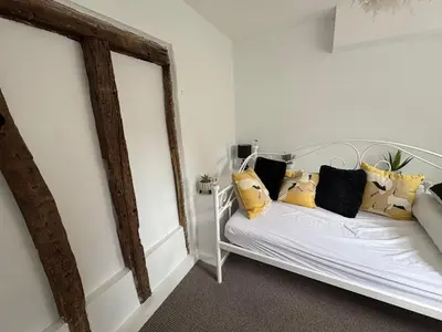 a bedroom with a white bed with yellow pillows at Stylish Town House in Medieval Grid in Bury Saint Edmunds