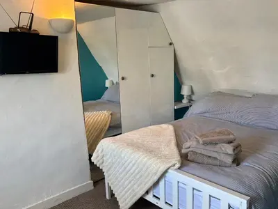 a bedroom with a bed with a mirror and a tv at Stylish Town House in Medieval Grid in Bury Saint Edmunds