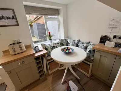 a small kitchen with a white table and a couch at Stylish Town House in Medieval Grid in Bury Saint Edmunds