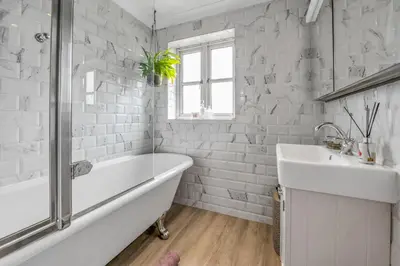 a white bathroom with a tub and a sink at Stylish 3 bedroom townhouse for 5 guests, set in the medieval grid with off street parking in Bury Saint Edmunds