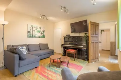 a living room with a couch and a piano at 4 Bed Central Home - Perfect Location with Parking in Cambridge