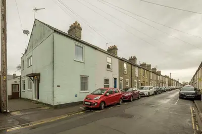 a row of houses on a street with parked cars at 4 Bed Central Home - Perfect Location with Parking in Cambridge