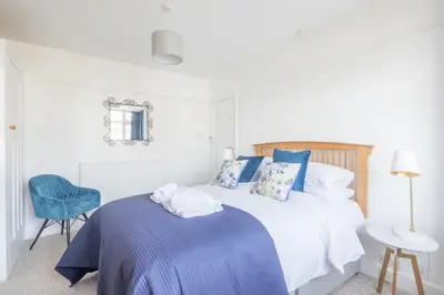 a bedroom with a bed and a blue chair at Charming Central Family Home in Cambridge
