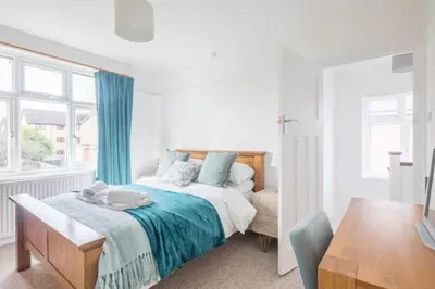 a white bedroom with a bed and a window at Charming Central Family Home in Cambridge
