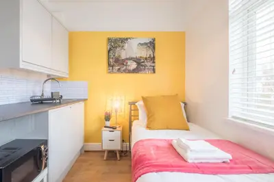 a small bedroom with a bed and a kitchen at The Modern Cambridge Studio 3 in Cambridge