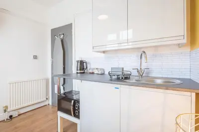 a kitchen with white cabinets and a sink at The Modern Cambridge Studio 3 in Cambridge