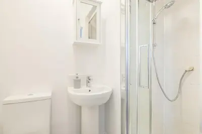 a white bathroom with a sink and a shower at The Modern Cambridge Studio 4 in Cambridge