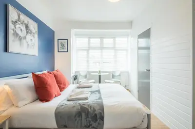 a bedroom with a large white bed with orange pillows at The Modern Cambridge Studio 4 in Cambridge