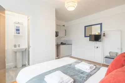 a white room with a bed and a sink at The Modern Cambridge Studio 4 in Cambridge