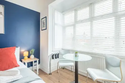 a bedroom with a bed and a table and a window at The Modern Cambridge Studio 4 in Cambridge