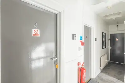 a glass door in a hallway with a fire extinguisher at The Modern Cambridge Studio 4 in Cambridge