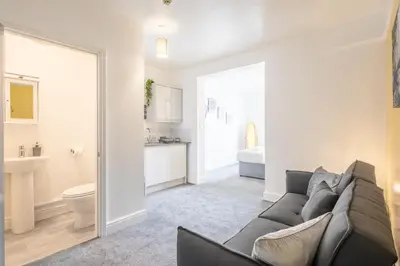 a living room with a couch and a bathroom at The Modern Cambridge Studio 5 in Cambridge