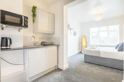 a kitchen and a bedroom with a bed in a room at The Modern Cambridge Studio 5 in Cambridge
