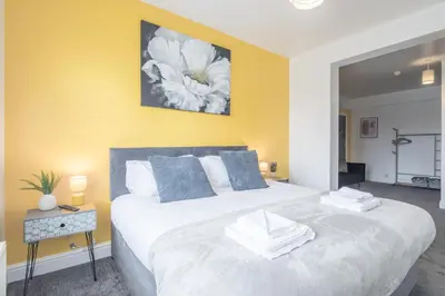 a bedroom with a large white bed with blue pillows at The Modern Cambridge Studio 5 in Cambridge