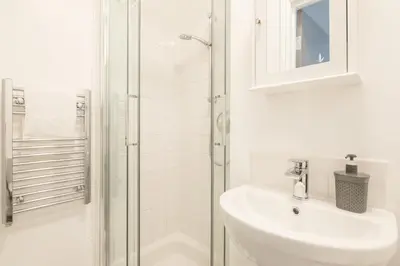 a white bathroom with a sink and a shower at The Modern Cambridge Studio 5 in Cambridge