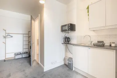 a kitchen with white cabinets and a microwave at The Modern Cambridge Studio 5 in Cambridge