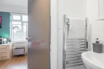 a white bathroom with a sink and a towel rack at The Modern Cambridge Studio 6 in Cambridge