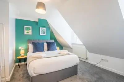 a bedroom with a bed with blue and green walls at The Modern Cambridge Studio 7 in Cambridge