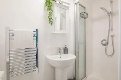 a white bathroom with a sink and a shower at The Modern Cambridge Studio 7 in Cambridge