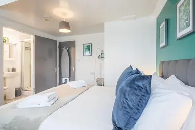 a bedroom with a large white bed with blue walls at The Modern Cambridge Studio 7 in Cambridge