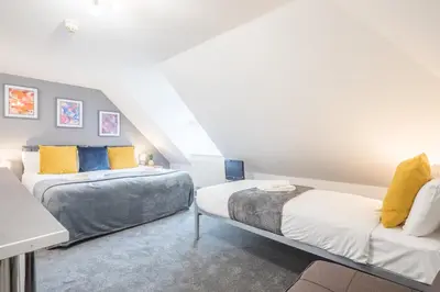 a bedroom with two beds and a staircase at The Modern Cambridge Studio 8 in Cambridge