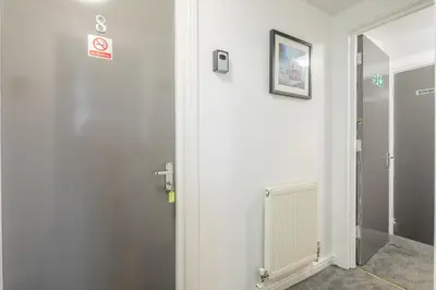 a white room with a door and a radiator at The Modern Cambridge Studio 8 in Cambridge