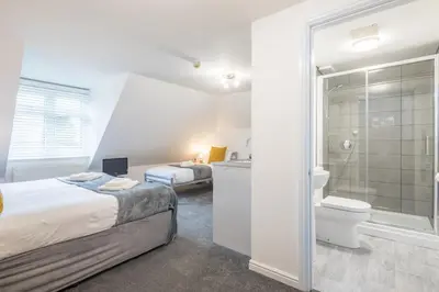 a bedroom with a bed and a bathroom with a shower at The Modern Cambridge Studio 8 in Cambridge