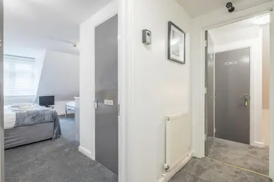 a bedroom with a door leading to a bedroom with a bed at The Modern Cambridge Studio 8 in Cambridge