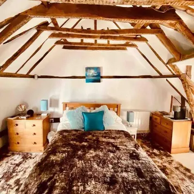 a bedroom with a large bed with blue pillows at The Nutshell in West Mersea